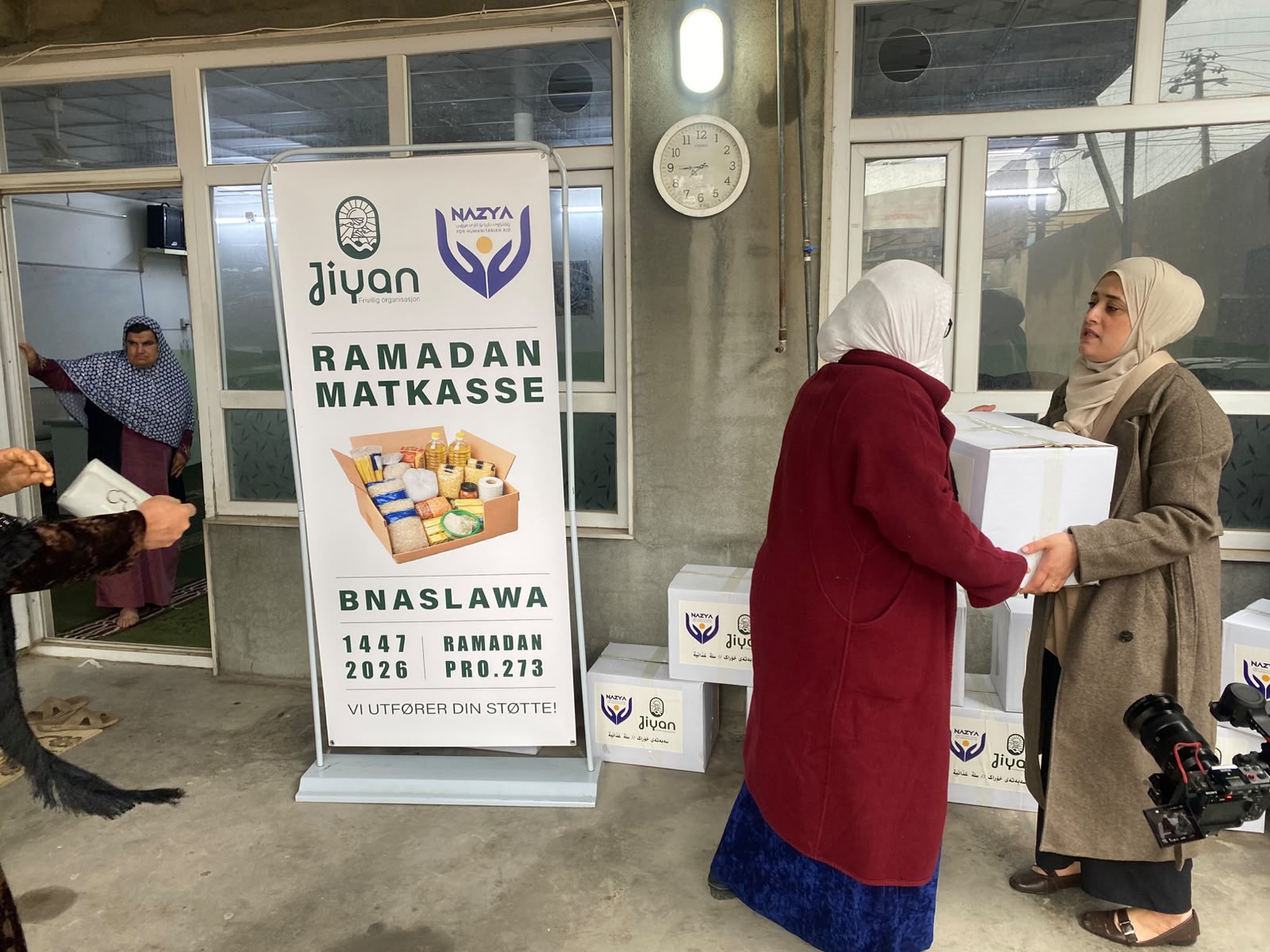 Nazya Organization distributing Ramadhan food baskets containing rice, oil, dates, and essential goods to families in Kurdistan